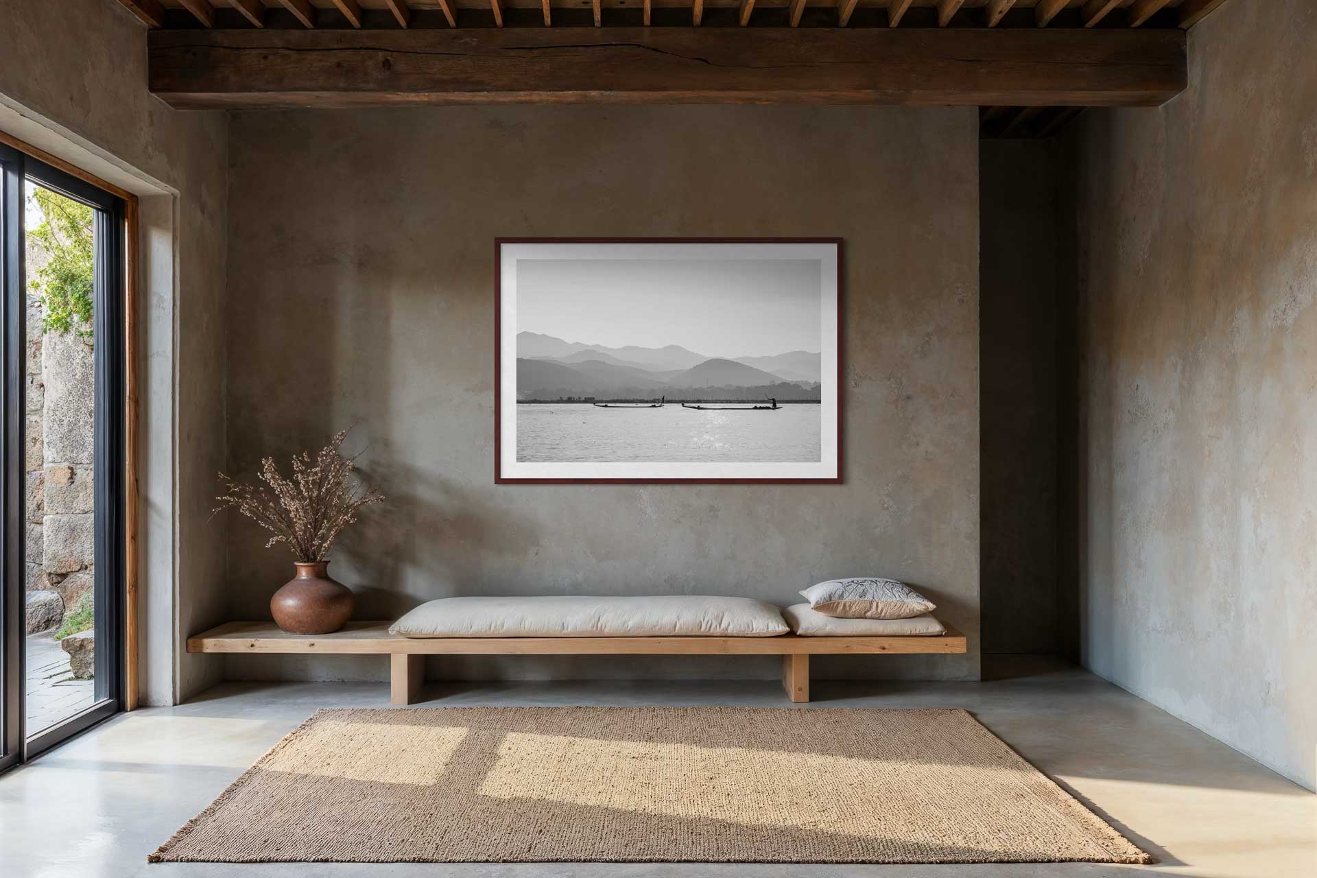 Schwarzweissaufnahme vom Inle Lake in Myanmar mit traditionellen Booten vor sanfter Bergkulisse.