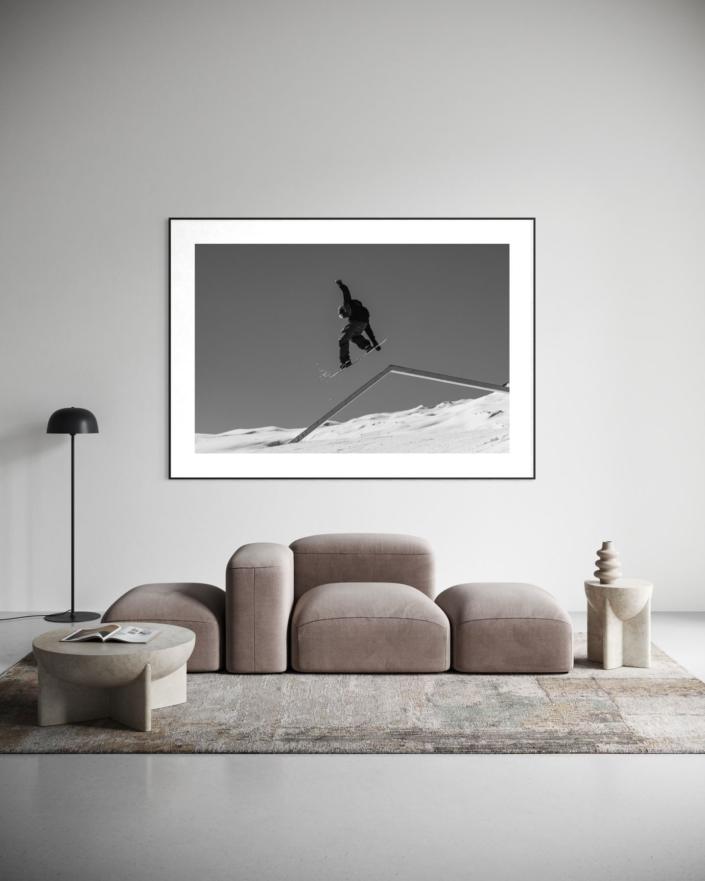 Dynamische Schwarzweissaufnahme eines Snowboarders in Laax, der über ein Rail springt.