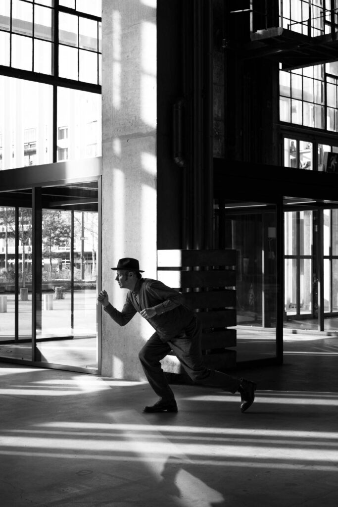 Portraitfotograf Z&uuml;rich: Matija l&auml;uft als Silhouette vor Industriegeb&auml;ude